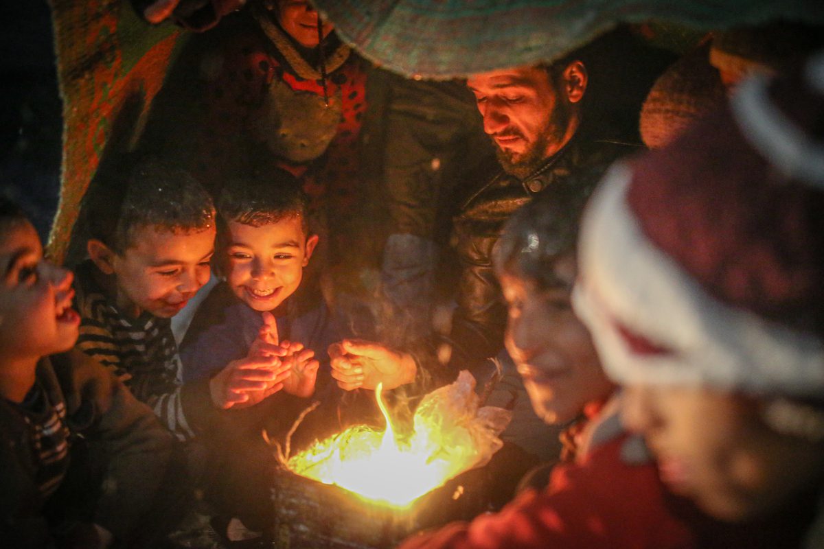 IDLIB, SYRIA - JANUARY 26: Refugee Syrian kids gather around fire to stay warm in a camp during winter season in Idlib, Syria on January 26, 2022. Civilians are forced to burn their clothes to stay warm at night, due to harsh winter conditions. ( Muhammed Said - Anadolu Agency )
