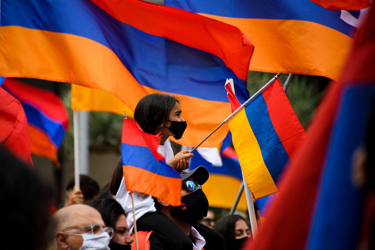 A girl waves an Armenian flag as people protest outside of the Turkish Consulate on 24 April 2021 [PATRICK T. FALLON/AFP/Getty Images]