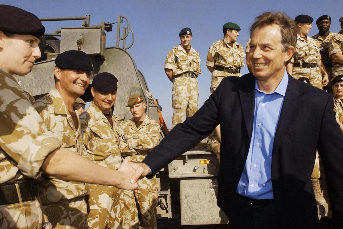 British Prime Minister Tony Blair meets troops as he arrives in Basra for a visit to British soldiers in Iraq, 04 January 2004. [STEFAN ROUSSEAU/AFP via Getty Images]