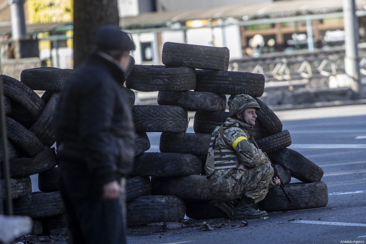 A Ukrainian soldier is seen behind tires in Zhuliany neighbourhood of Kyiv during Russia’s military invasion of Ukraine, on February 26, 2022 [Aytaç Ünal / Anadolu Agency]