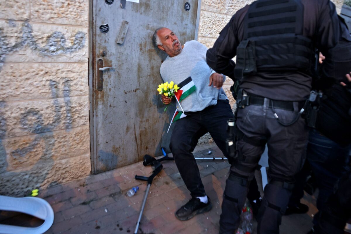 Israeli policemen scuffle with Palestinian Jerusalemite activist during a protest in Sheikh Jarrah in Israeli-annexed east Jerusalem on February 18, 2022 [AHMAD GHARABLI/AFP via Getty Images]