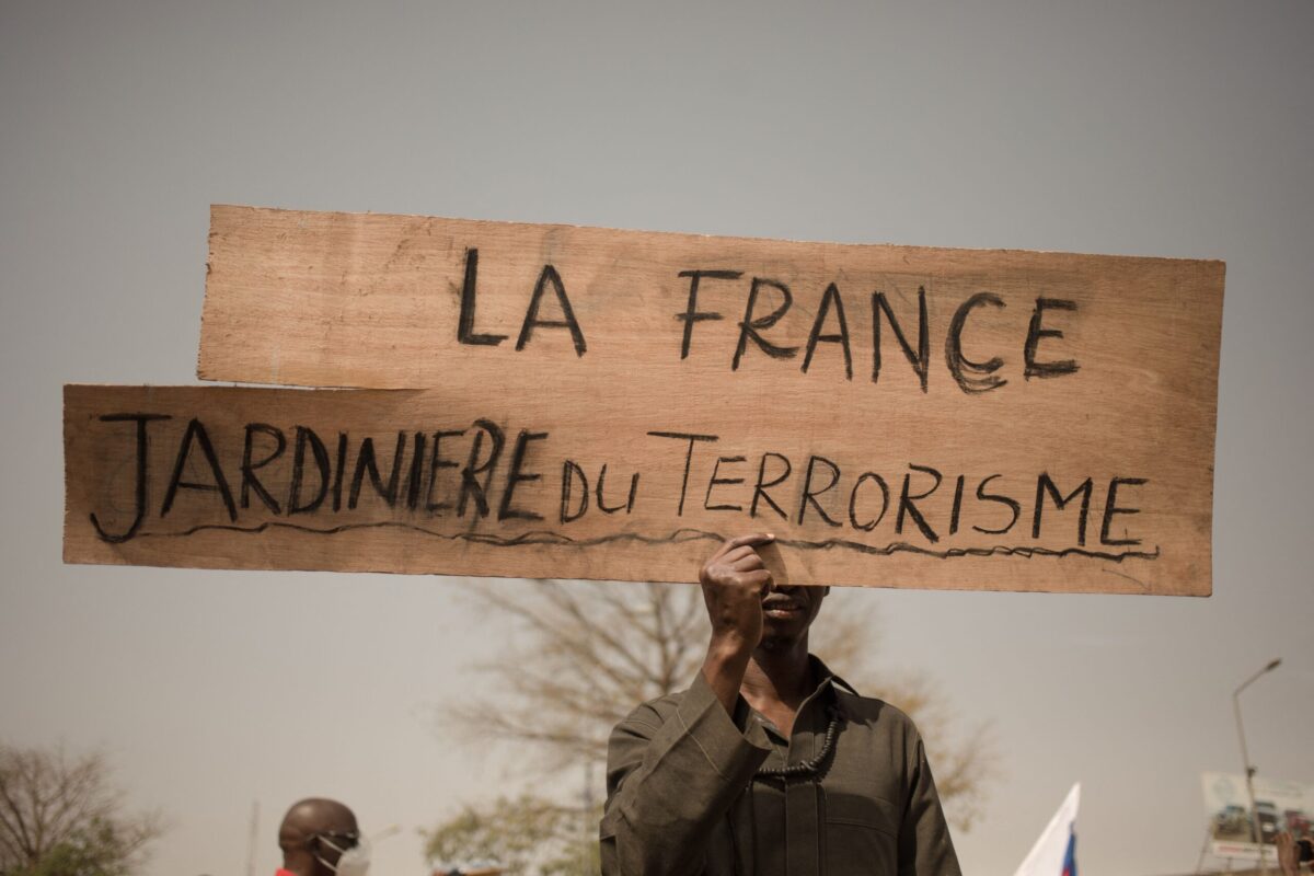 TOPSHOT - A protester holds a placard reading "France, gardener of terrorism" during a demonstration organised by the pan-Africanst platform Yerewolo to celebrate France's announcement to withdraw French troops from Mali, in Bamako, on February 19, 2022. - The French president announced on Febraury 16 the withdrawal of troops from Mali after a breakdown in relations with the nation's ruling military junta. France first intervened in Mali in 2013 to combat a jihadist insurgency that emerged one year prior. The French pull-out after nearly a decade is also set to see the smaller European Takuba group of special forces, created in 2020, leave Mali. (Photo by FLORENT VERGNES / AFP) (Photo by FLORENT VERGNES/AFP via Getty Images)