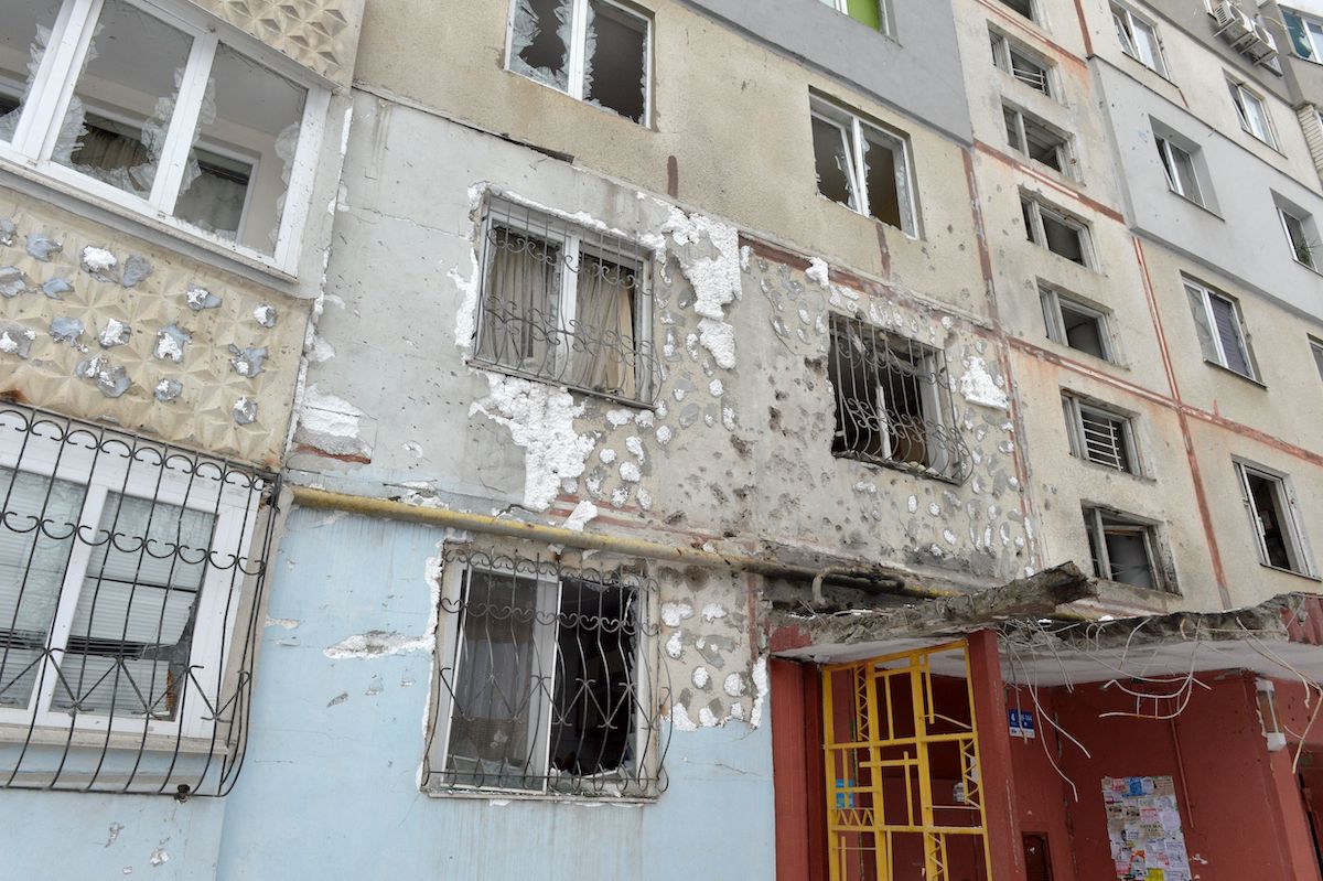 A view of a residential building damaged by recent shelling in Kharkiv on 26 February 2022. [SERGEY BOBOK/AFP via Getty Images]