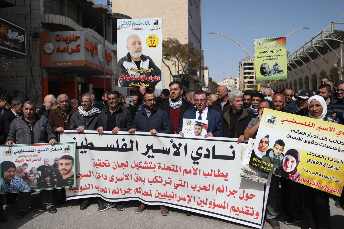 Palestinian protesters holding banners gather during a demonstration to support Palestinian prisoners in Israeli jails, Hebron on 1 March 2022. [Mamoun Wazwaz - Anadolu Agency]