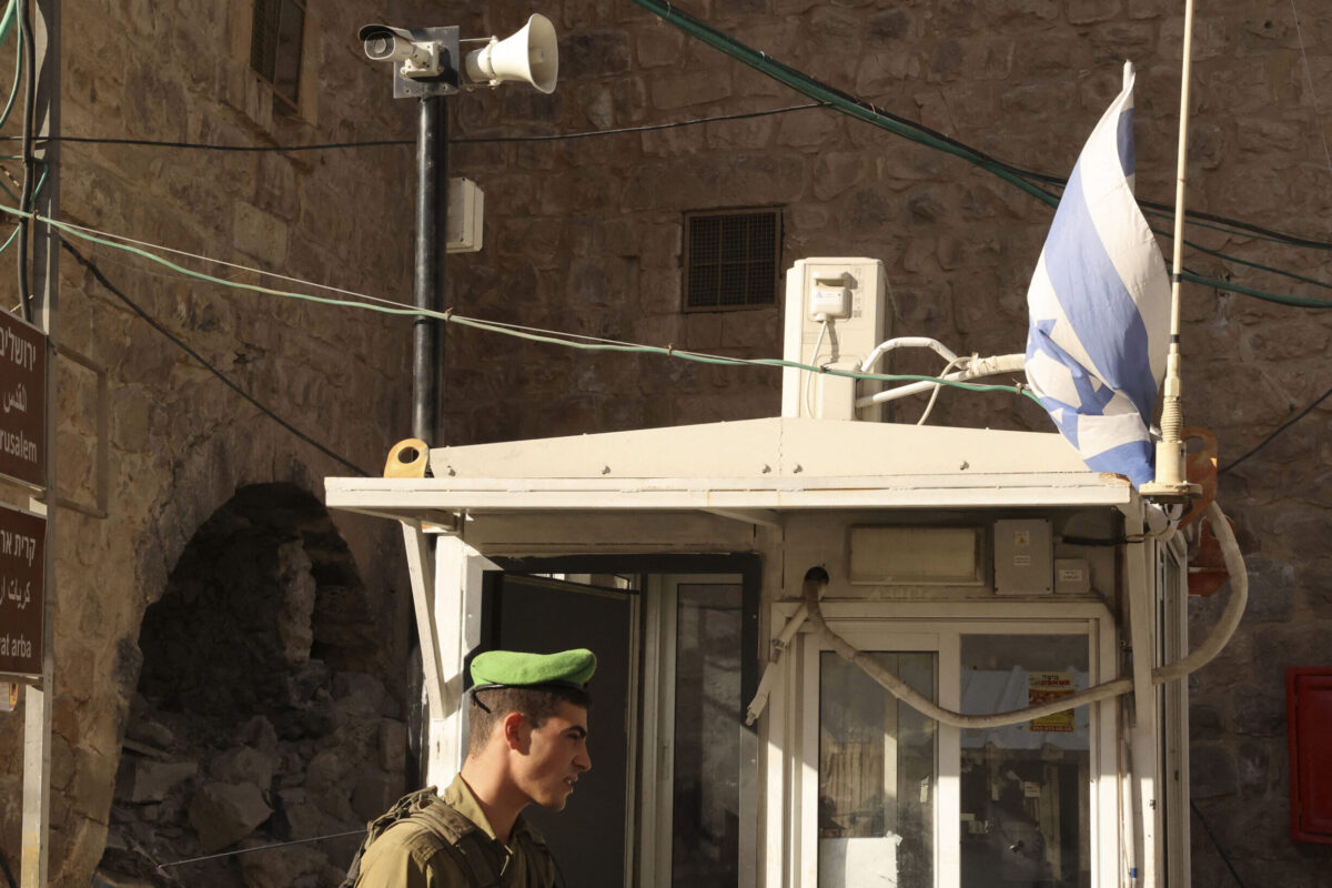 An Israeli soldier stands under a surveillance camera at a checkpoint in the flashpoint Palestinian city of Hebron on November 9, 2021 [HAZEM BADER/AFP via Getty Images]