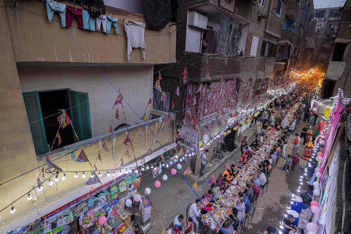 Muslims gather along a street-long table to break their Ramadan fast in Cairo, Egypt on 16 April 2022 [KHALED DESOUKI/AFP/Getty Images]