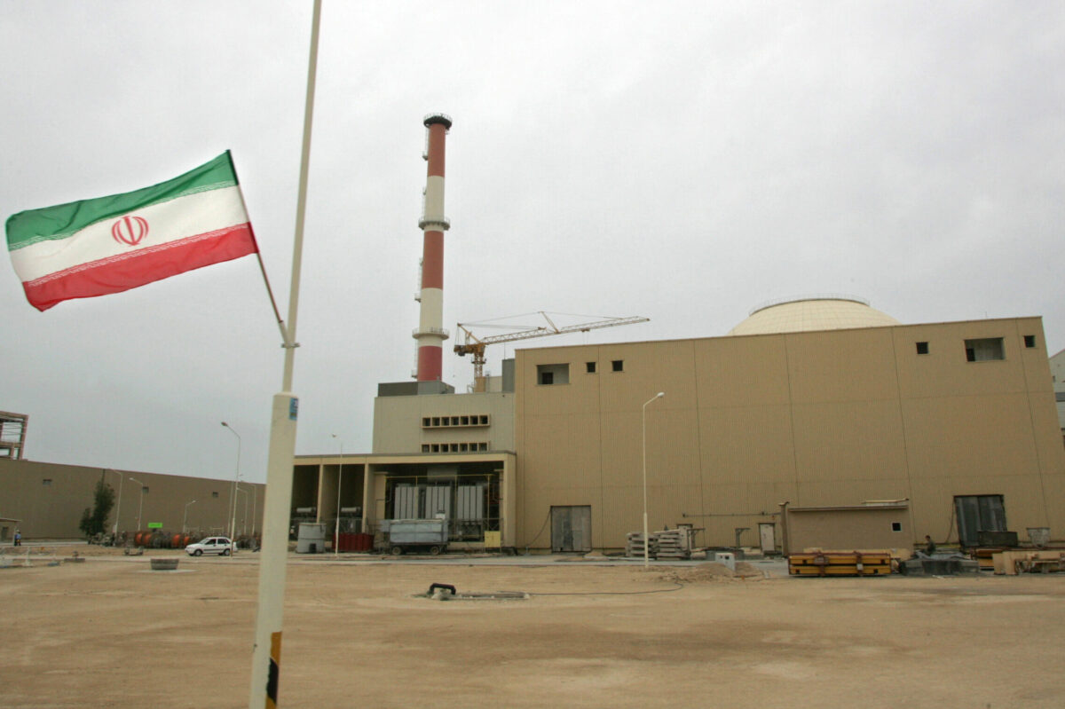 File picture dated April 3, 2007 shows an Iranian flag outside the building housing the reactor of the Bushehr nuclear power at plant Natanz facility [BEHROUZ MEHRI/AFP FILES/AFP via Getty Images]
