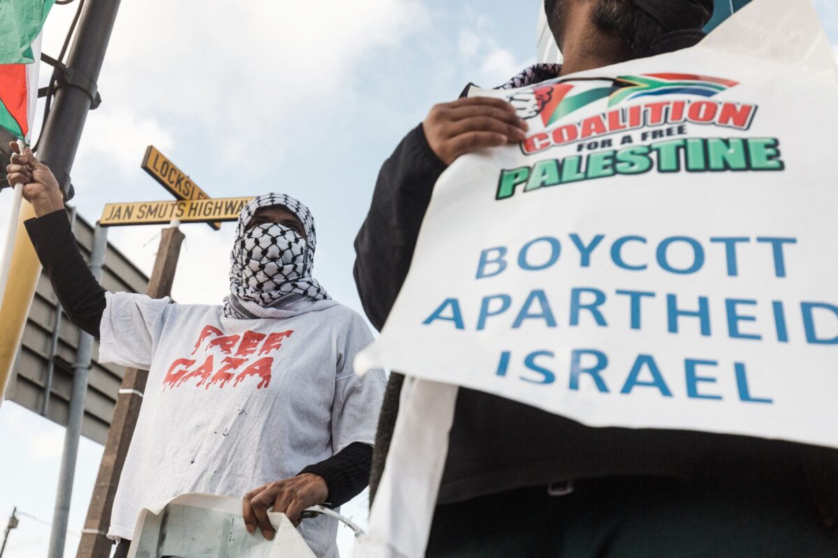 Pro-Palestinian supporters hold placards reading 'Boycott Apartheid Israel' on May 18, 2021 [RAJESH JANTILAL/AFP via Getty Images]