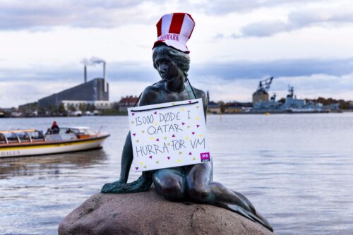 A hat in the Danish colours and a sign reading "15,000 deaths in Qatar, Hooray for the World Cup" has been placed on the bronze statue "The Little Mermaid" in Copenhagen's harbour on October 13, 2021 [ODD ANDERSEN/AFP via Getty Images]
