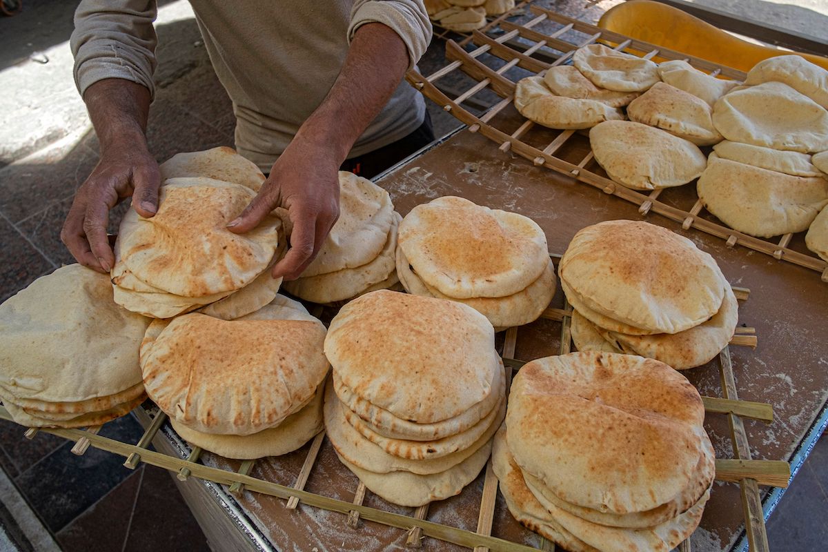 vEgyptian men work in a bakery at a market in Cairo, on March 17, 2022. [KHALED DESOUKI/AFP via Getty Images]