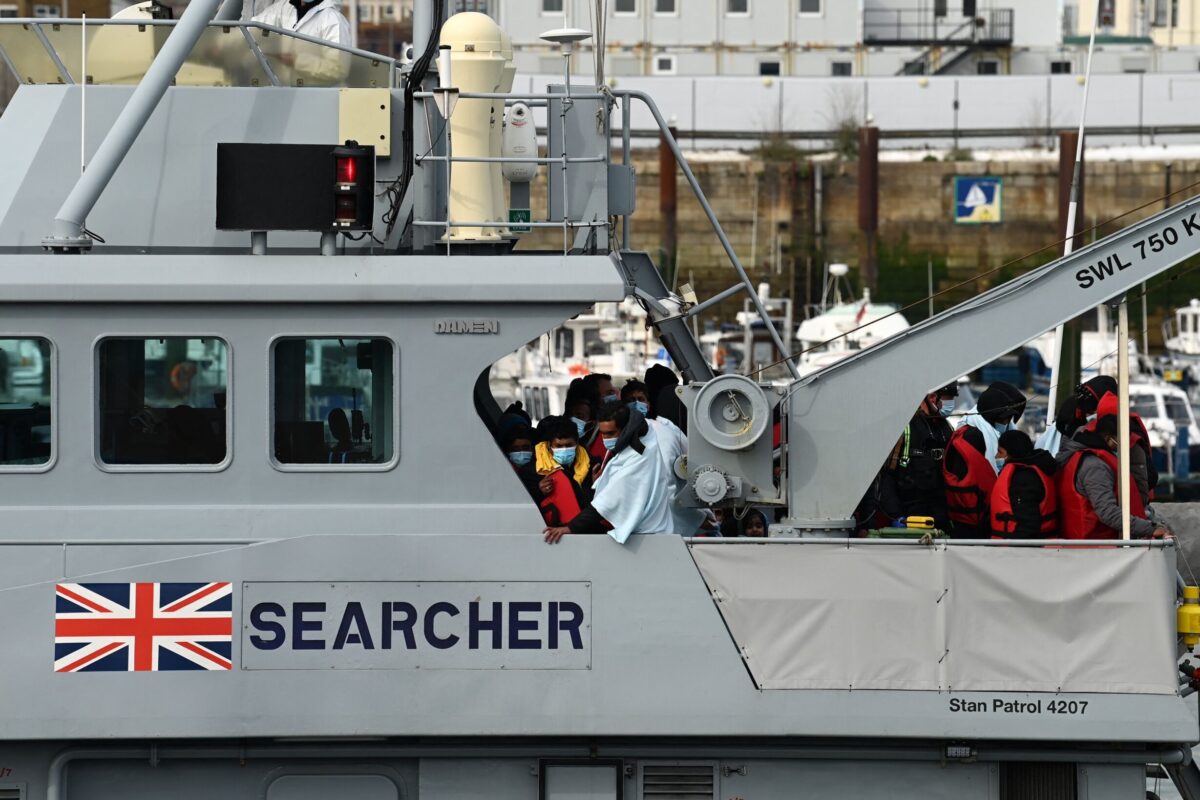 Migrants huddle together, brought to port by the UK Border Force after being picked up crossing the English Channel from France [GLYN KIRK/AFP via Getty Images]