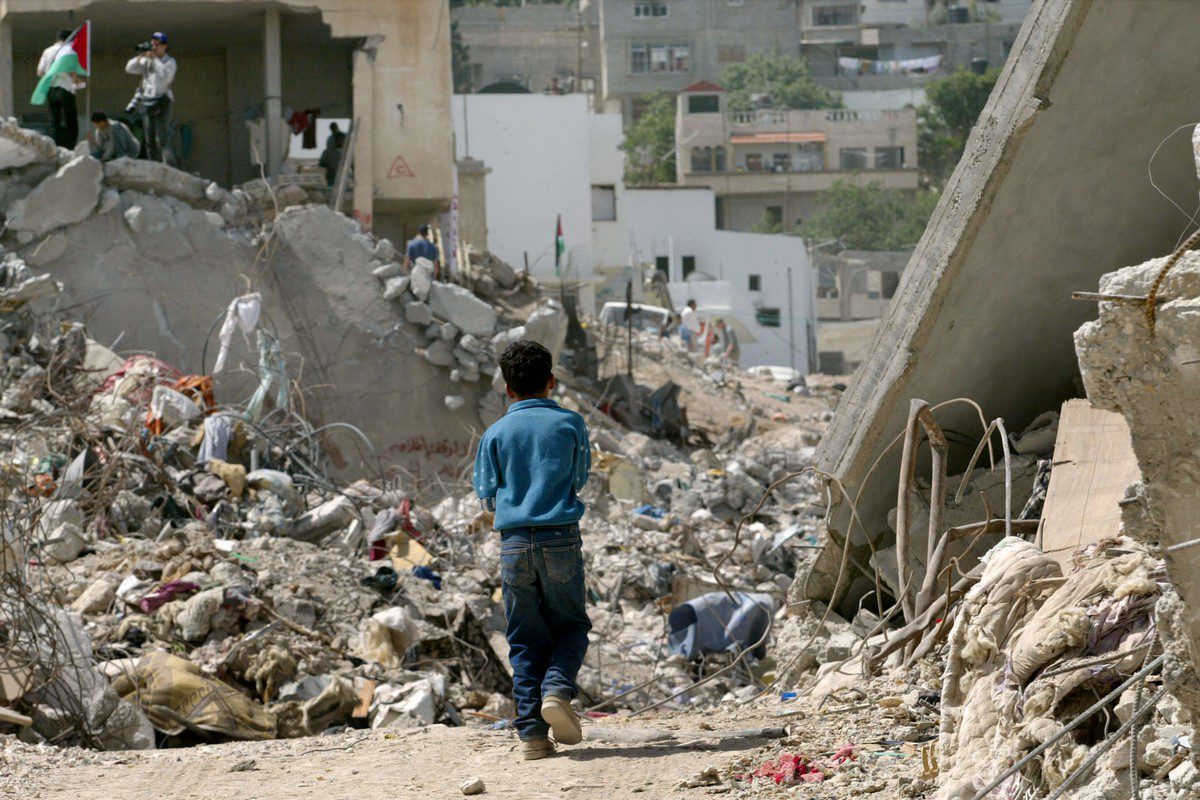 A Palestinian boy walks between the rubble from destroyed homes in the Jenin refugee camp on 13 May 2002 [David Silverman/Getty Images]
