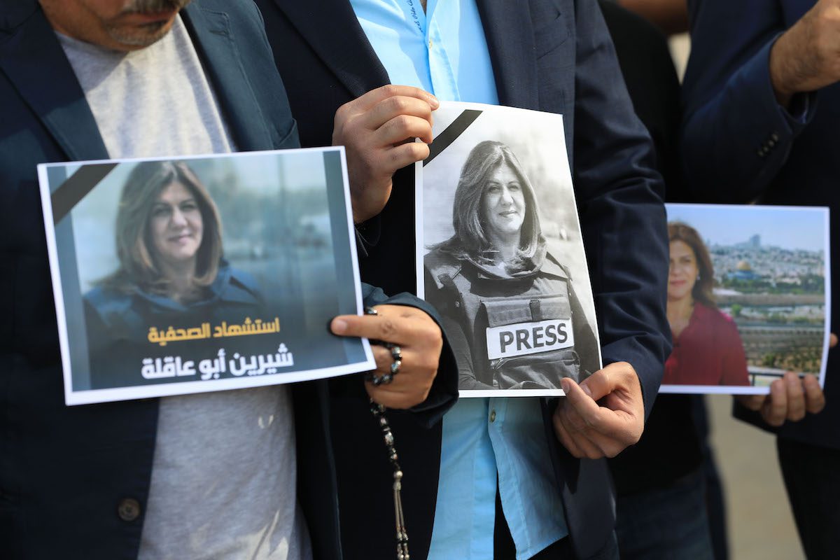 Iraqi journalists holding the photos of Al Jazeera journalist Shireen Abu Akleh after she was killed while covering an Israeli raid in West Bank on May 11, 2022, during a protest outside Al Jazeera office in Baghdad, Iraq. [Murtadha Al-Sudani - Anadolu Agency]
