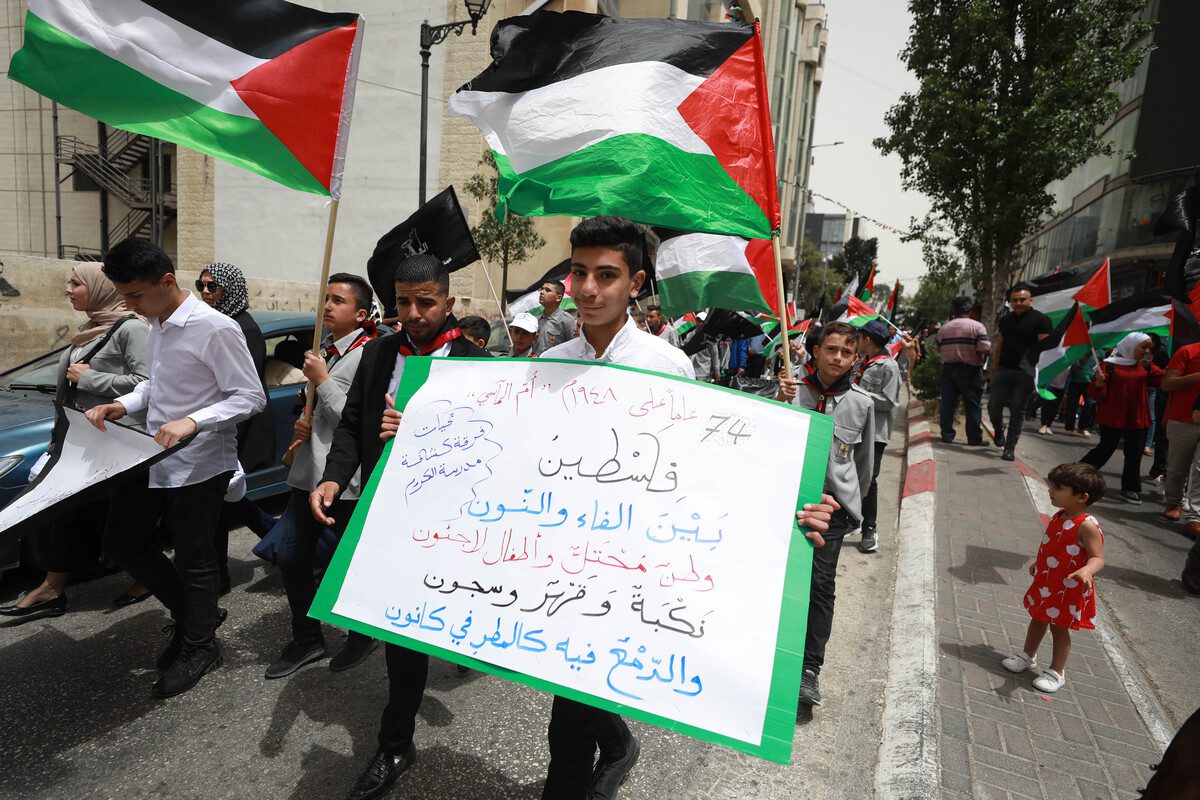 People take part in a demonstration with Palestinian flags and banners on the 74th anniversary of the Nakba, in Ramallah, West Bank on May 15, 2022 [Issam Rimawi - Anadolu Agency]