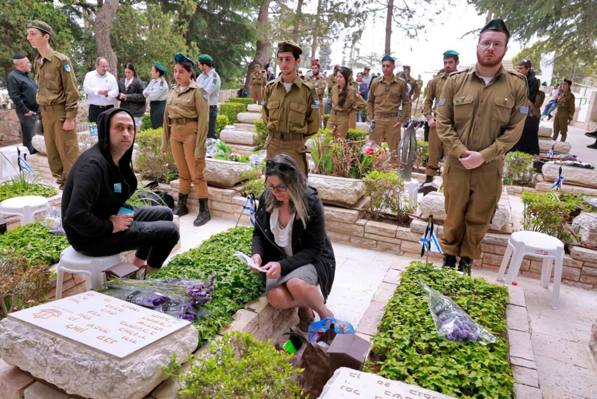 Israeli soldiers and mourners visit graves at the Mount Herzel military cemetery in Jerusalem at the start of Remembrance Day commemorating fallen soldiers, on May 4 2022. - Israel mark the Remembrance Day to commemorate 24,068 fallen soldiers and victims of attacks since 1860, according to the Ministry of Defence, just before the celebrations of the 74th anniversary of its creation according to the Jewish calendar. (Photo by Menahem KAHANA / AFP) (Photo by MENAHEM KAHANA/AFP via Getty Images)