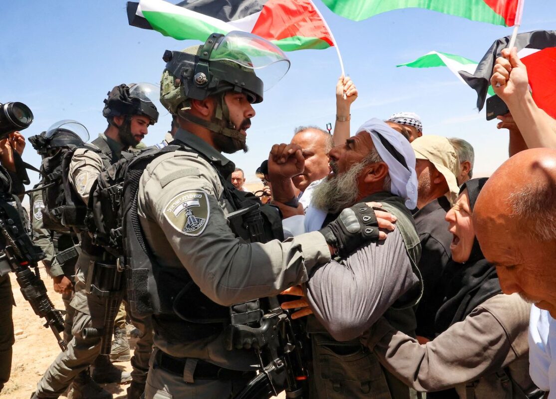 An elderly Palestinian man faces member of the Israeli forces as Israeli [HAZEM BADER/AFP via Getty Images]
