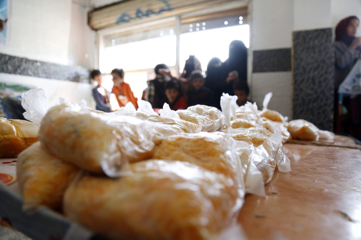 People affected by war wait to receive free meals provided by a charitable kitchen in the Mseek area on April 03, 2022 in Sana'a, Yemen [Mohammed Hamoud/Getty Images]