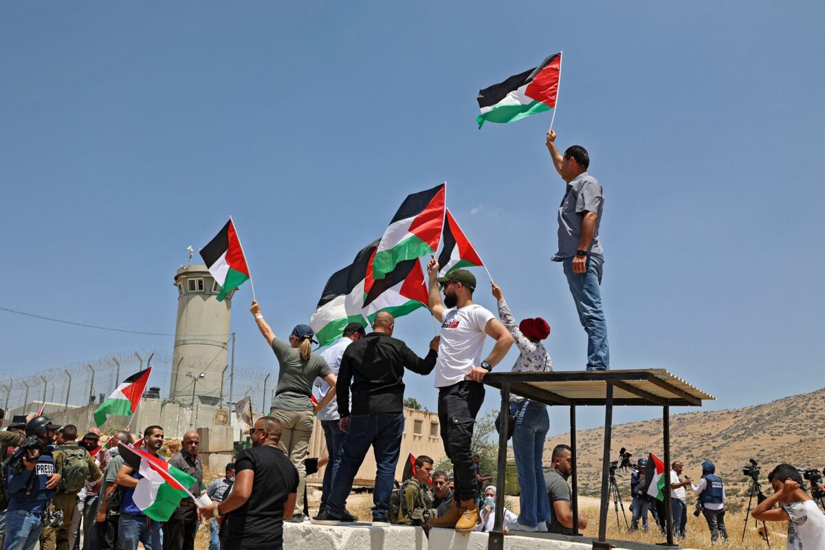 Palestinian demonstrators wave the national flag in the city of Tubas on June 6, 2022 [JAAFAR ASHTIYEH/AFP via Getty Images]