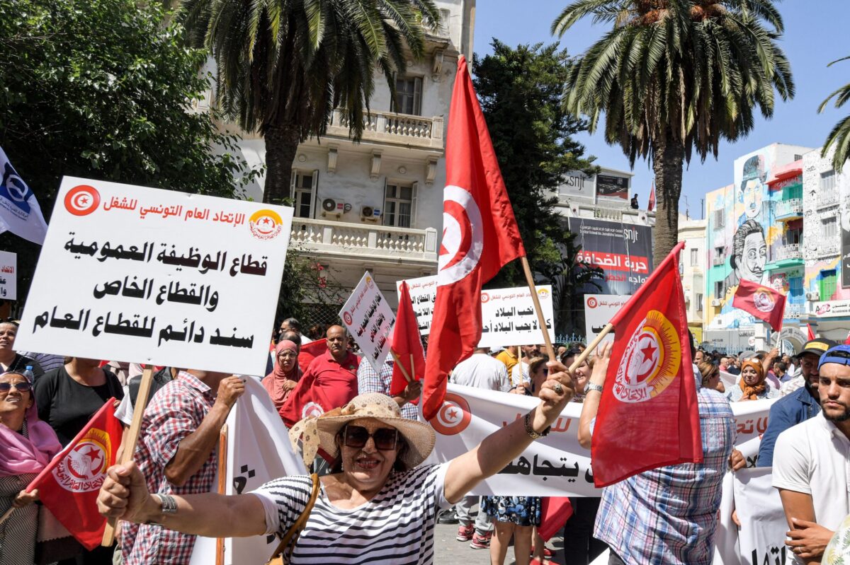 Supporters of the Tunisian General Labour Union (UGTT) gather with national flags during a rally outside its headquarters in the capital Tunis [FETHI BELAID/AFP Getty Images]