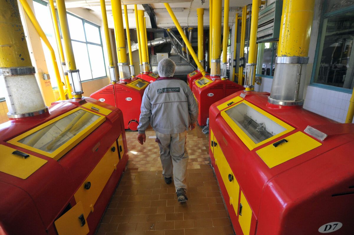 An employee walks past corn milling machines [Oliver Bunic/Bloomberg via Getty Images]