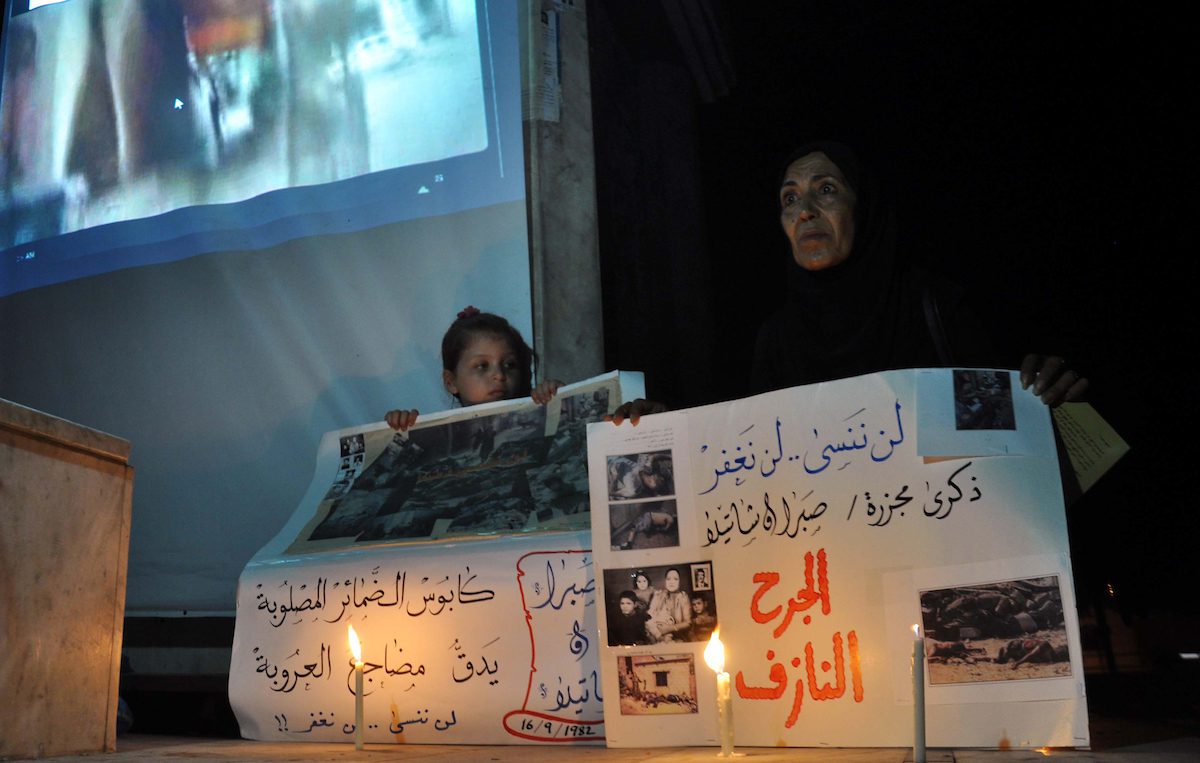 A Palestinian woman and her duaghter hold placards in a protest marking the 48th anniversary of the Sabra and Shatila massacre in 1982, in Gaza City September 16, 2014. [Mohammed Talatene/Apaimages]