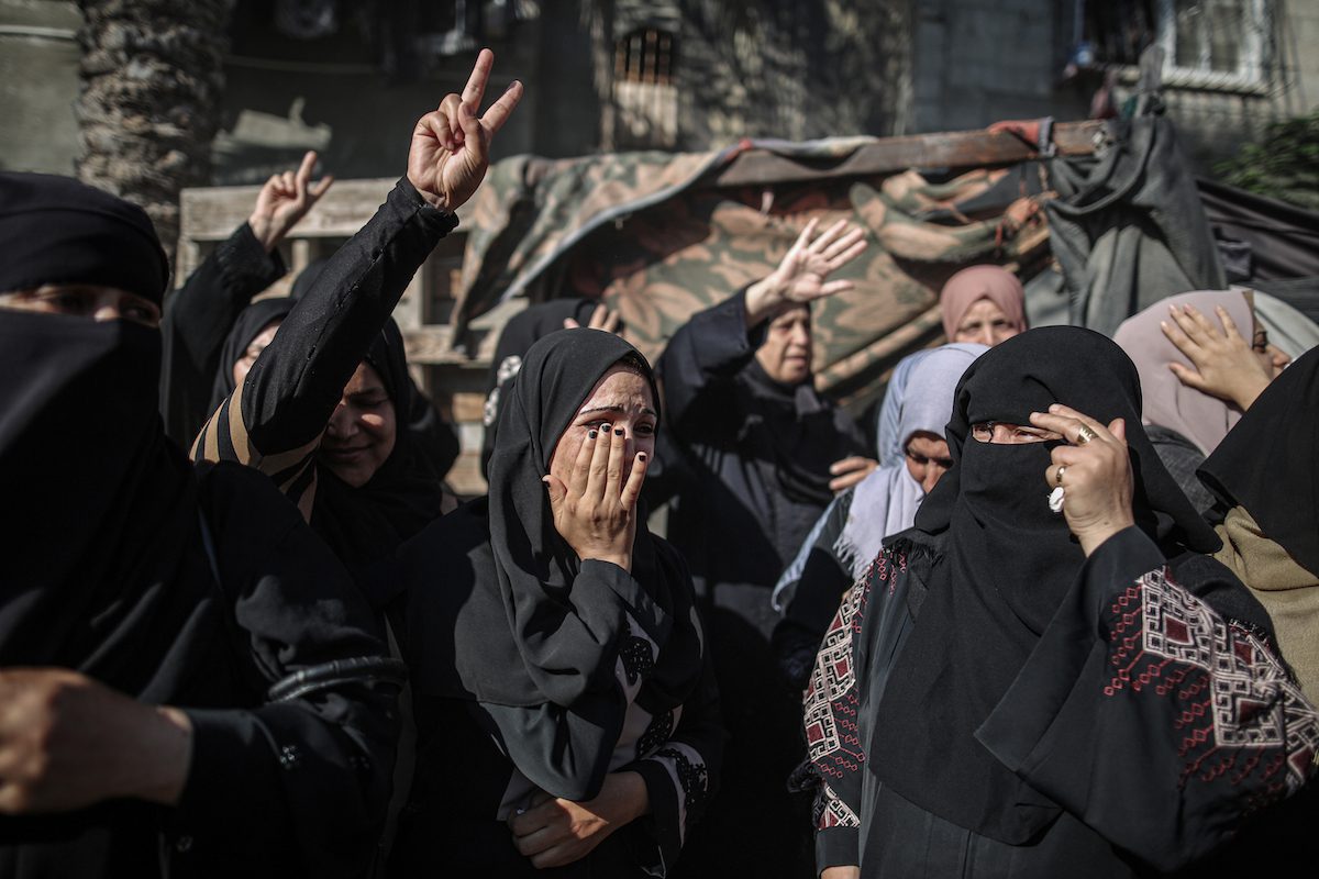 Relatives mourn the death of Palestinian children who were killed by Israeli air strikes in Gaza on 11 August 2022 [Ali Jadallah/Anadolu Agency]