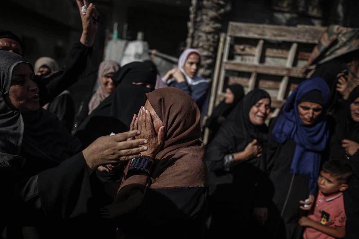 Relatives mourn the death of Palestinian children who were killed by Israeli air strikes in Gaza on 11 August 2022 [Ali Jadallah/Anadolu Agency]