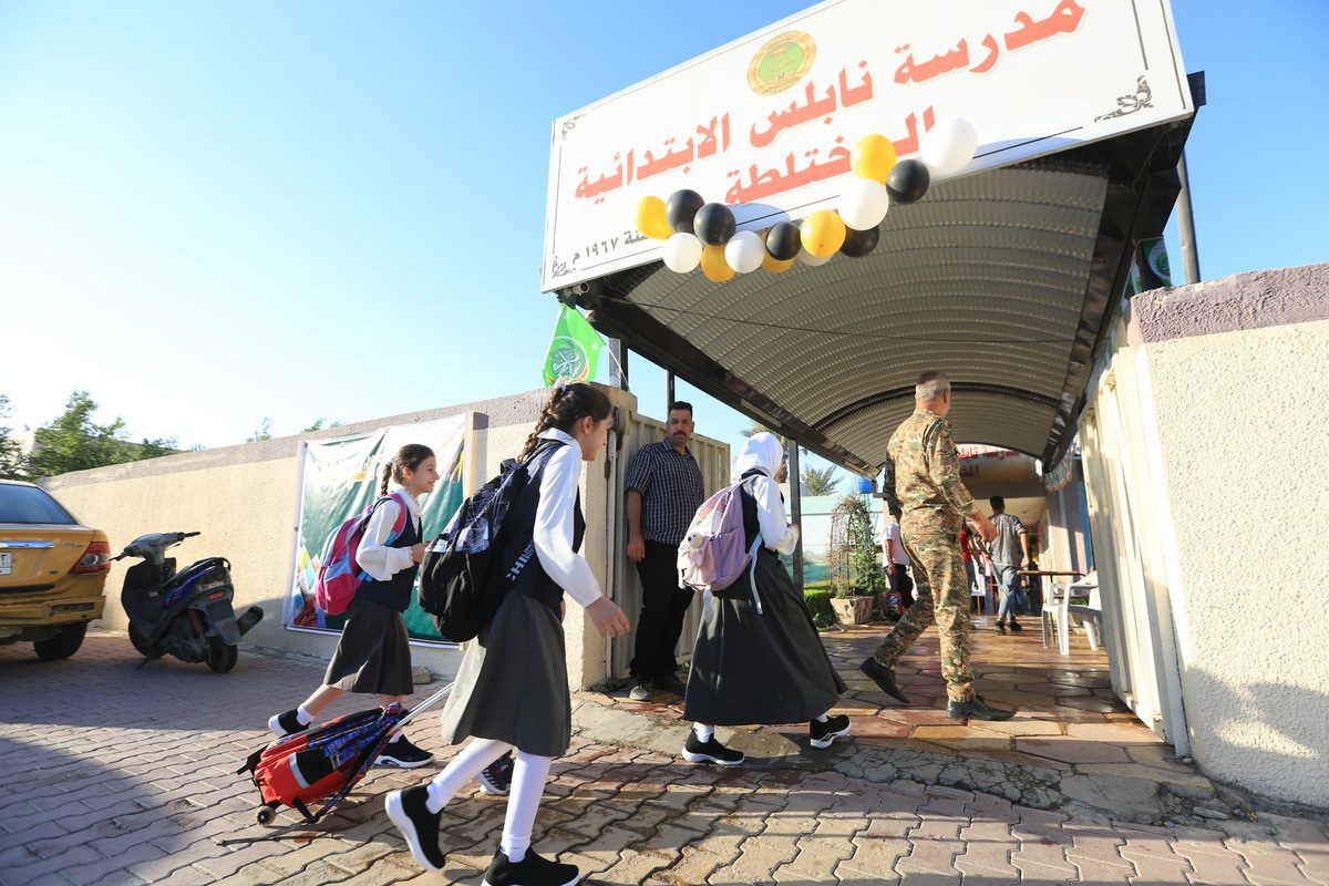 Iraqi elementary students enter their schools in Baghdad, Iraq on October 12, 2022. [ Murtadha Al-Sudani - Anadolu Agency ]