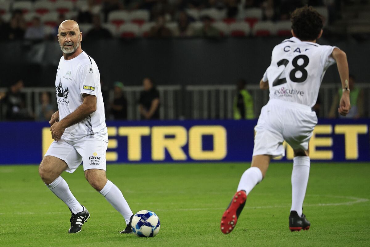 Former French football player Eric Cantona (L) plays the ball next to his son Emir during the football and rugby union "Match des Legendes" at the Allianz Riviera stadium in Nice, southeastern France, on September 26, 2022. [VALERY HACHE/AFP via Getty Images]