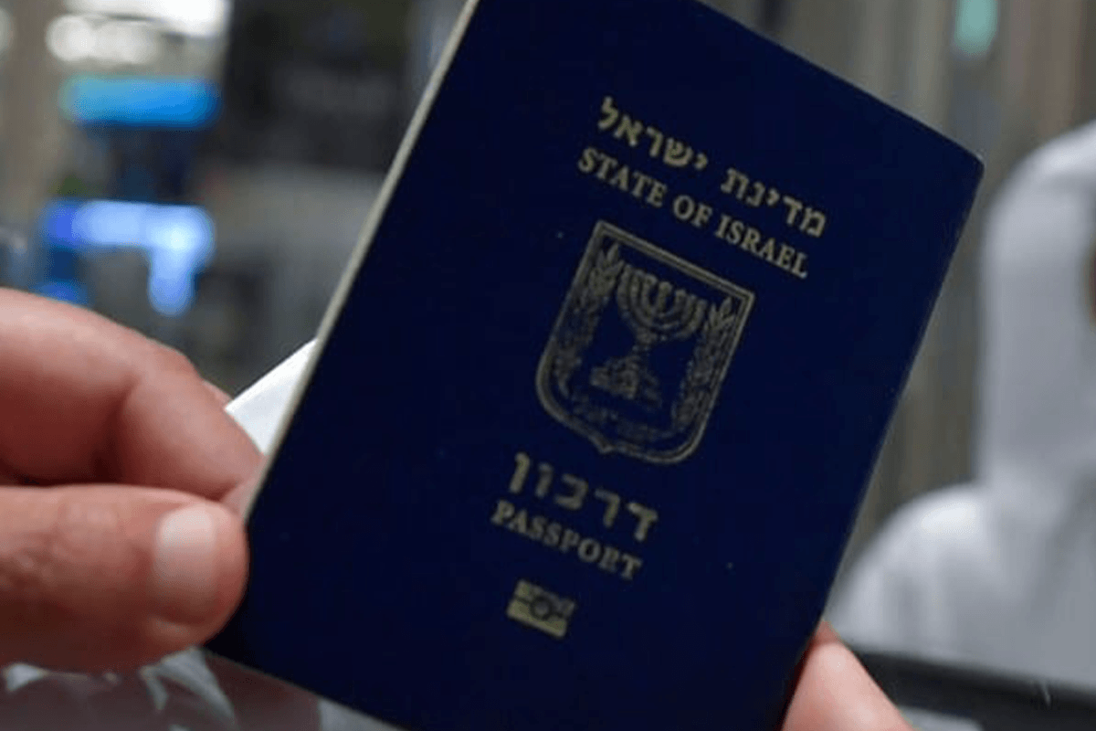 Man holds an Israeli passport on 26 November 2020 [KARIM SAHIB/AFP/Getty Images]