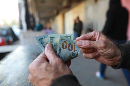 Citizens buy and exchange foreign currency at exchange office after exchange rate falls after the Country's Central Bank President changed in Baghdad, Iraq on January 25, 2023. [Murtadha Al-Sudani - Anadolu Agency]