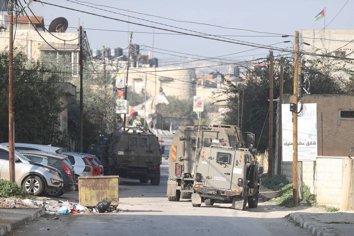 A view of military vehicles as Palestinians clash with Israeli soldiers after Israeli forces raided the refugee camp and killed 9 Palestinians in Jenin, West Bank on January 26, 2023. [Issam Rimawi - Anadolu Agency]