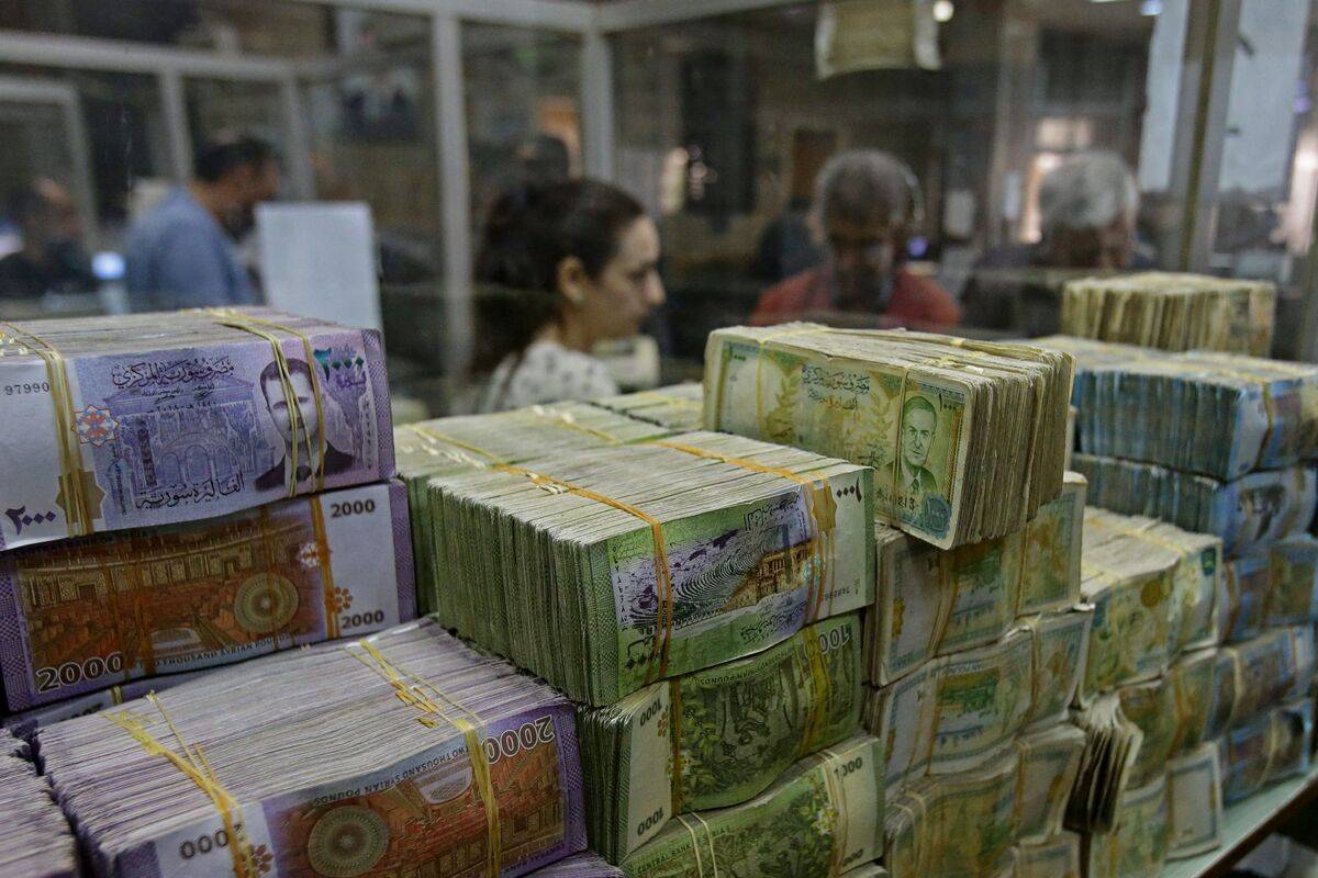Syrian lira banknotes at the Commercial Bank of Syria in Damascus, on November 10, 2022. [Photo by LOUAI BESHARA/AFP via Getty Images]