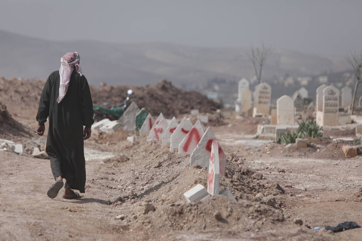 A Syrian earthquake survivor searches for the graves of his relatives who lost their lives in quakes [Bekir Kasım - Anadolu Agency]