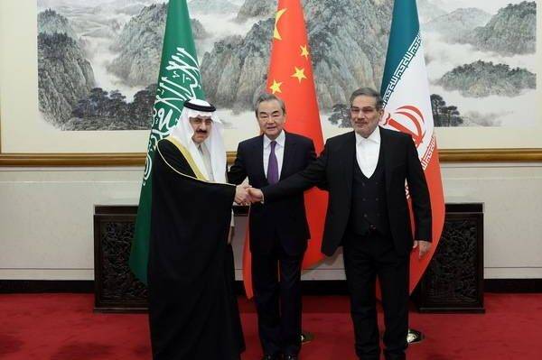 Iran's top security official Ali Shamkhani (R), Chinese Foreign Minister Wang Yi (C) and Musaid Al Aiban, the Saudi Arabia's national security adviser, pose for a photo after Iran and Saudi Arabia agree to resume diplomatic ties after several days of deliberations in Beijing, China on 10 March 2023 [Chinese Foreign Ministry]