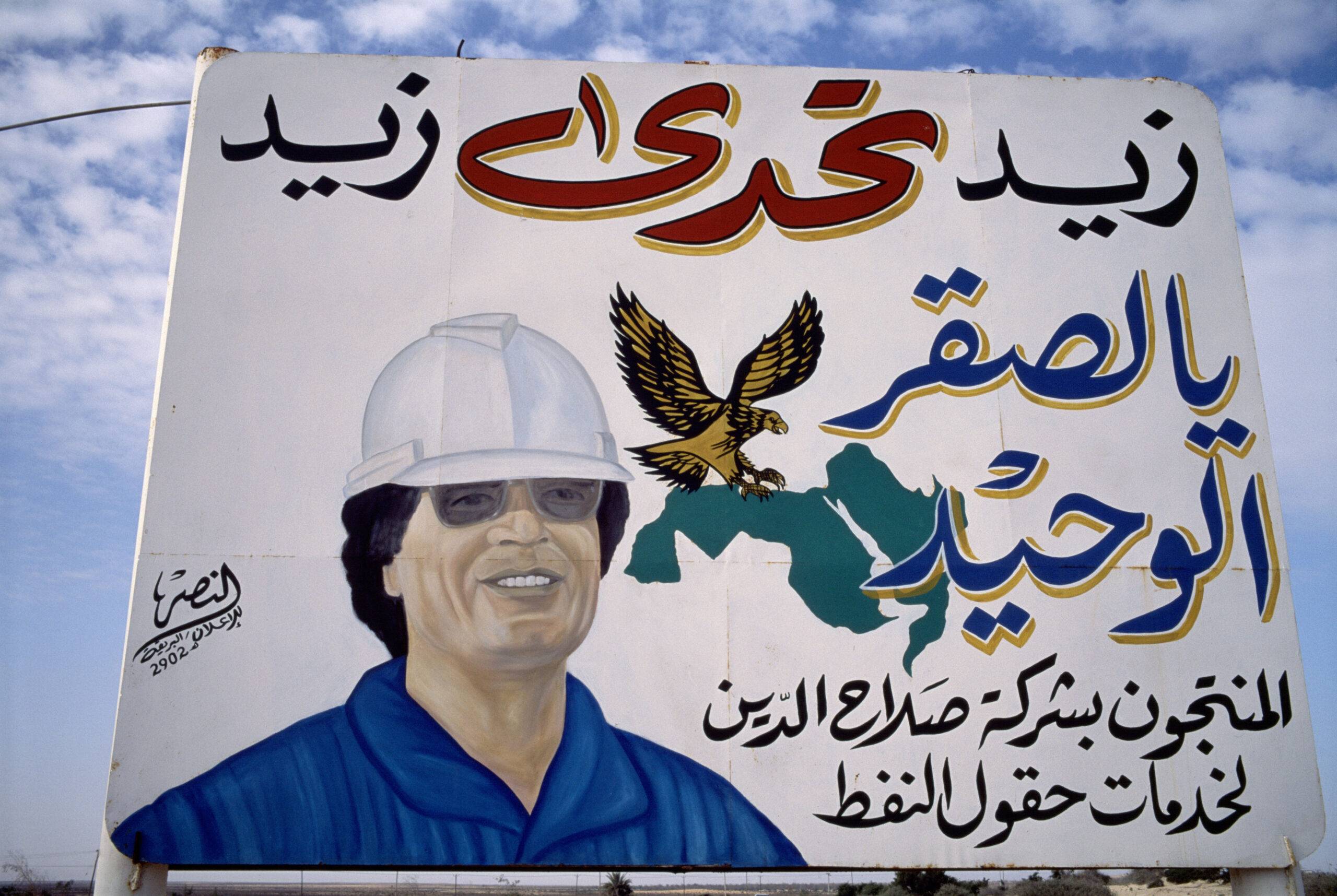 A portrait of Libyan leader Moammar Gadhafi, portraying him as a construction worker, is displayed at the pipe-manufacturing plant for the Great Man-Made River project March 2000 in Brega, Libya [Reza/Getty Images]
