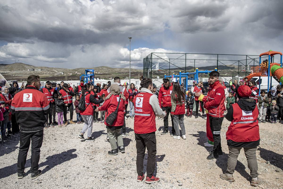 Turkish Red Crescent volunteers dance with earthquake survivor children at the container city after devastating earthquakes hit multiple provinces of Turkiye including on March 30, 2023 [Hilmi Tunahan Karakaya - Anadolu Agency]