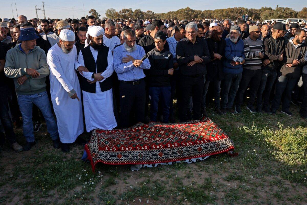 Mourners pray over the body of 26-year-old Arab Israeli medical student Mohammed al-Asibi, during his funeral in the Bedouin village of Hura in southern Israel on April 2, 2023 [AHMAD GHARABLI / AFP]