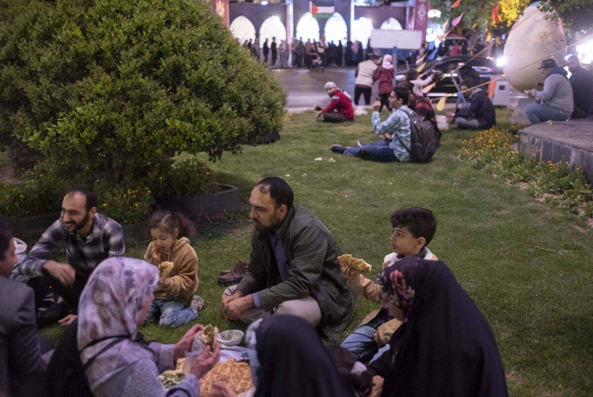 An Iranian family break their fast by eating the Iftar during an Arabian Iftar during the holy month of Ramadan in downtown Tehran, April 6, 2023 [Morteza Nikoubazl/NurPhoto via Getty Images]