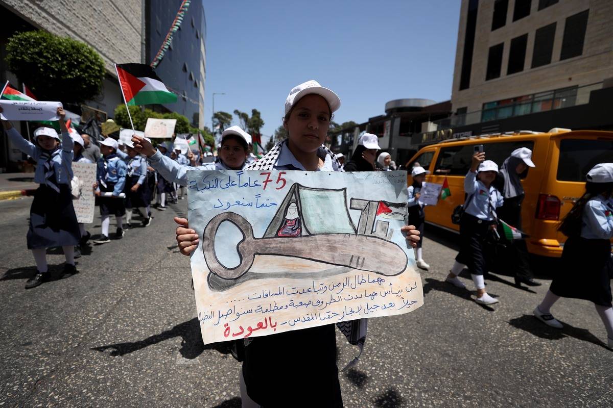 Palestinians march with banners on the 75th anniversary of Israel's declaration of independence, which Palestinians call the Great Catastrophe (Nakba), and its forced migration of Palestinians in Ramallah, West Bank on May 15, 2023 [Issam Rimawi/Anadolu Agency]