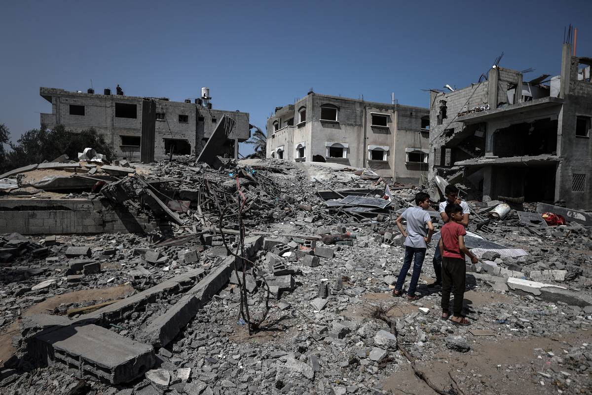 Children walk among the rubbles near the collapsed houses after Israeli attack launched in Gaza City, Gaza on May 23, 2023 [Ali Jadallah/Anadolu Agency]