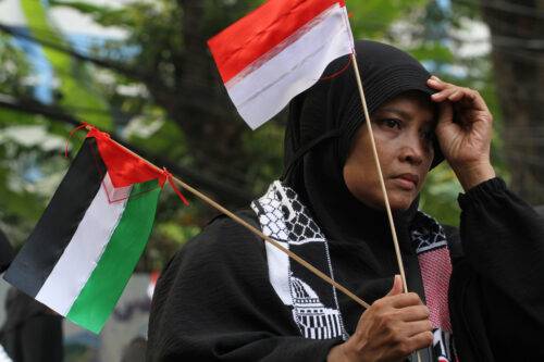 A woman holds a Palestinian and Indonesian flag together during peace protest at the in front of the Palestinian Embassy in Jakarta, Indonesia on May 29, 2023. [Eko Siswono Toyudho - Anadolu Agency]