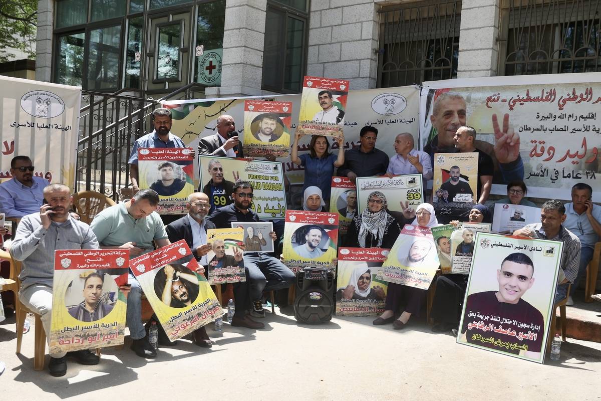 People, holding photos of prisoners, gather for a solidarity demonstration for Palestinian prisoners held in Israeli jails in front of Red Cross building in Ramallah, West Bank on May 30, 2023 [Issam Rimawi - Anadolu Agency]