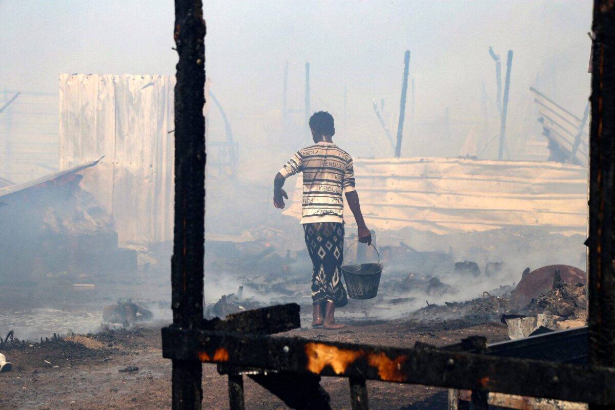 Yemenis put out flames after a fire broke out, burning dozens of huts, in Al-Jishah camp for the internally displaced in al-Khokha district on the southern edge of the Red Sea city of Hodeida, on November 12, 2022. (Photo by Khaled Ziad / AFP) (Photo by KHALED ZIAD/AFP via Getty Images)