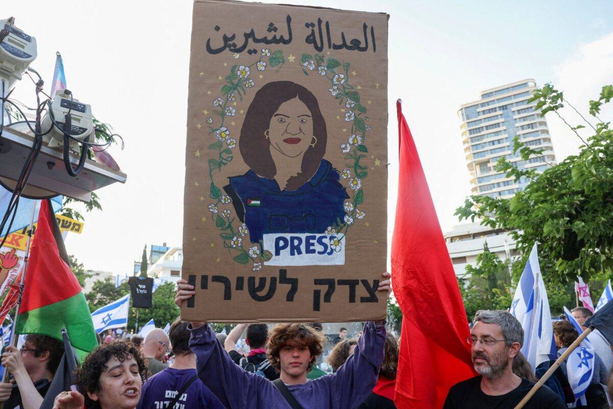 A demonstrator lifts a placard depicting slain Palestinian journalist Shireen Abu Akleh in Tel Aviv on May 20, 2023 [AHMAD GHARABLI/AFP via Getty Images]
