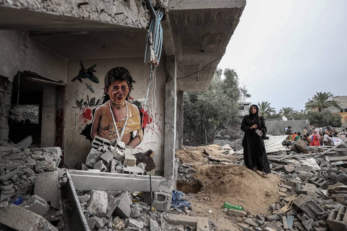 A 'Free Gaza' themed graffiti named 'Invasion Kills Children' and made by Palestinian artists is seen on the walls of demolished houses in Dayr al-Balah district of Gaza city, Gaza on June 08, 2023 [Ali Jadallah/Anadolu Agency]