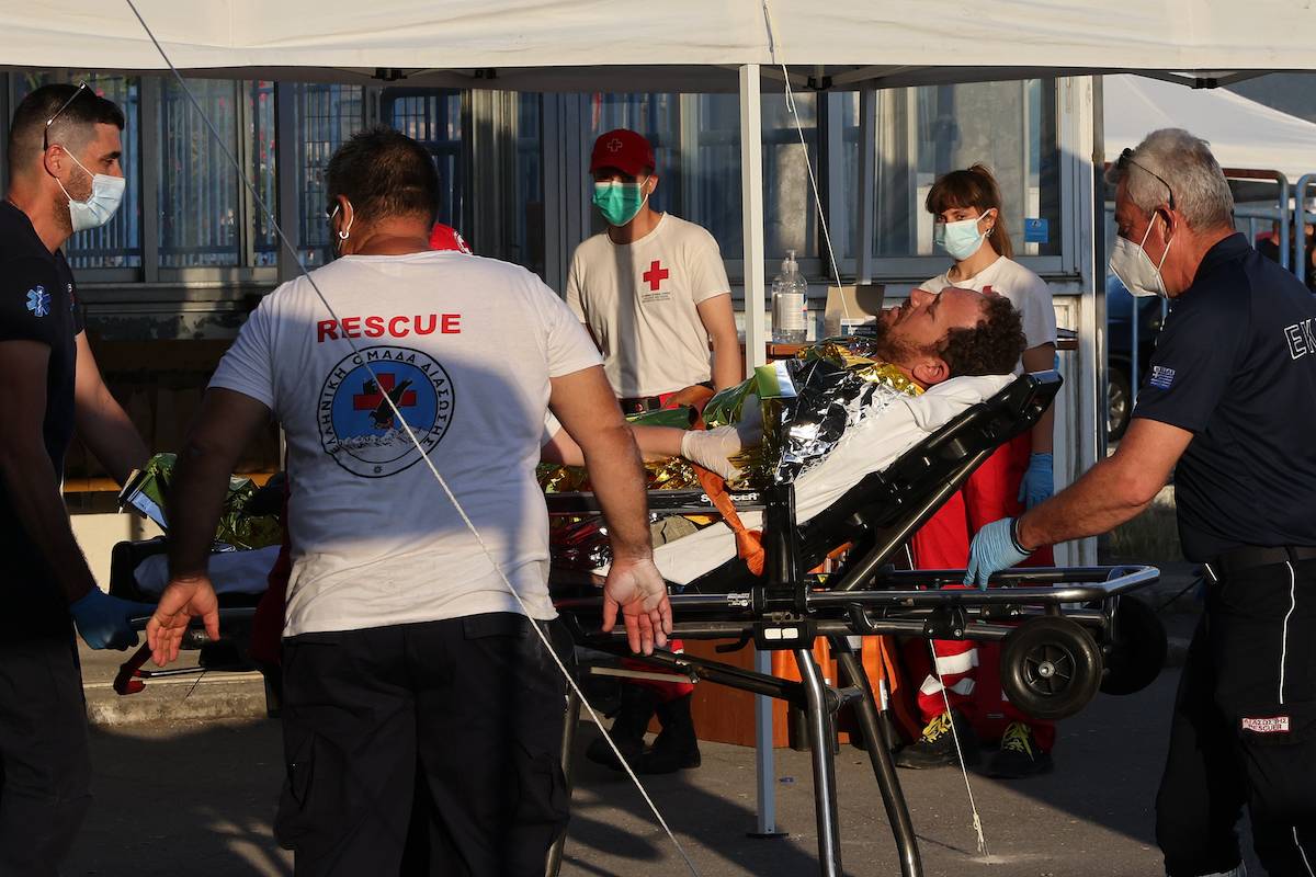 A migrant is transferred to hospital as rescued migrants find shelter at a depot, following a shipwreck offshore in Kalamata , Greece on June 14, 2023 [Costas Baltas - Anadolu Agency]