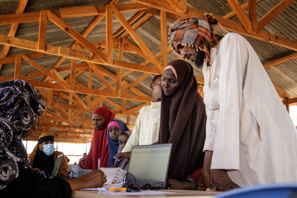 UNHCR staff Katra Abdullahi (L) talks with newly arrived Somali refugees at the profiling and resigtration centre in the Dadaab refugee camp, one of Africa's largest refugee camps in Kenya, on March 23, 2023 [BOBB MURIITHI/AFP via Getty Images]