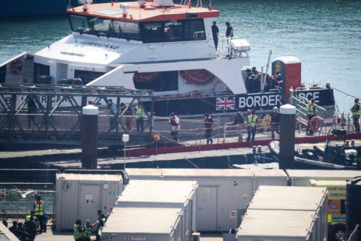 Migrants are escorted ashore from a UK Border Force vessel in Dover, southeast England, on June 15, 2023 [HENRY NICHOLLS/AFP via Getty Images]