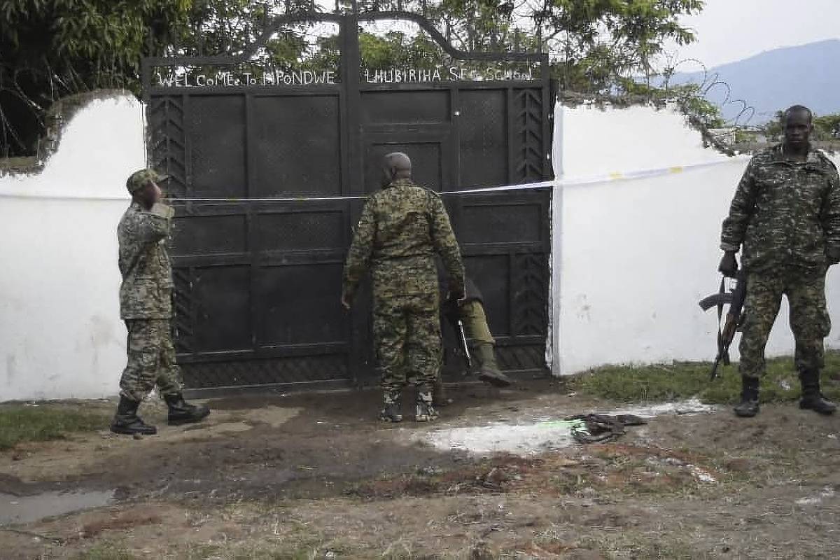 Uganda security forces are seen standing at the premises of an attack in Mpondwe, Uganda, on June 17, 2023 [Photo by -/AFP via Getty Images]